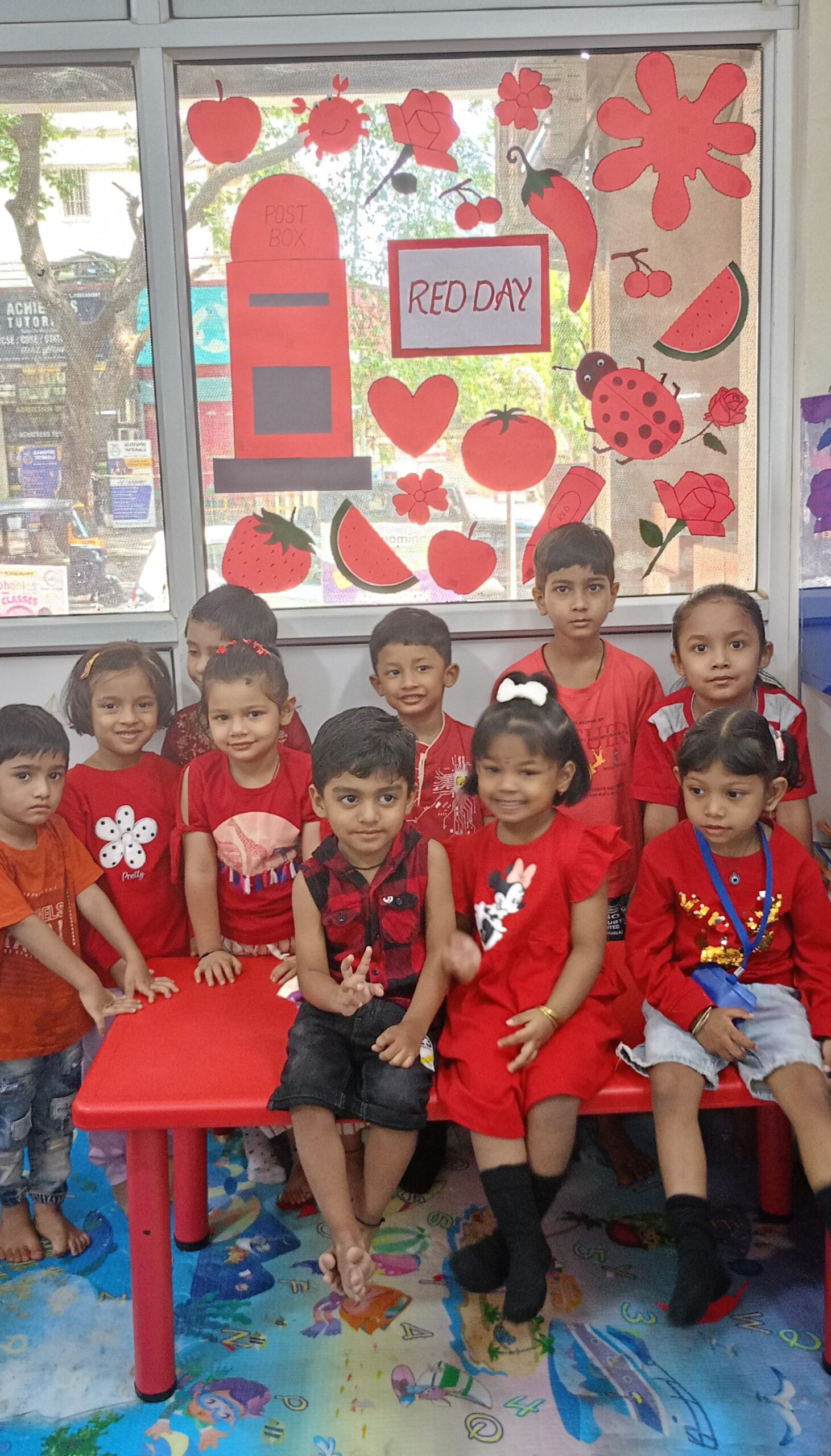 Child celebrating red day at preschool with classmates